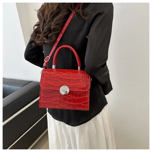 Détail du sac à bandoulière rouge en cuir verni gaufré croco avec fermoir argenté