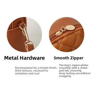 Details des hellgoldenen Metallverschlusses und Reißverschlusses an der braunen Stepptasche