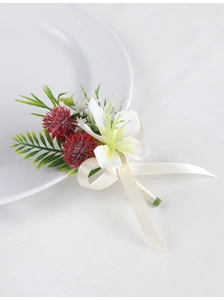 Detail of white faux lily and deep red thistle boutonniere with creamy silk ribbon
