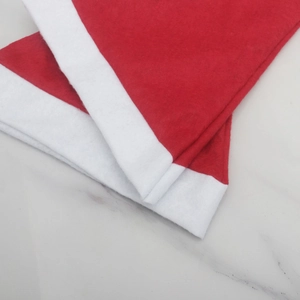 Close-up of a classic red and white Christmas hat on a white marble background