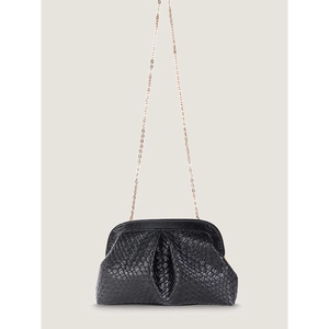 Detail of black woven texture dumpling bag with a delicate gold chain shoulder strap