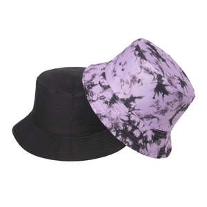 Dettaglio di un cappello a secchiello nero e un cappello da pescatore viola tie-dye