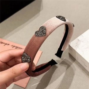 Macro detail of plush velvet headband with rhinestone heart charms in pink violet