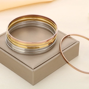 Detailed stack of thin titanium steel bangles in gold rose gold and silver mirror finish