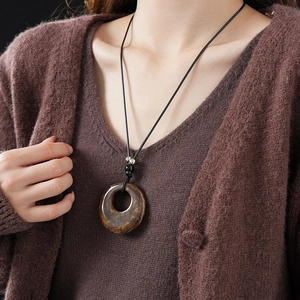 Detailed view of resin leopard print hoop pendant with beads on a black cord necklace
