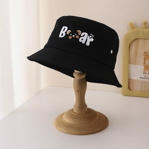 Détail d'un chapeau bob noir en coton avec broderie texte Bear et motif patte d'ours