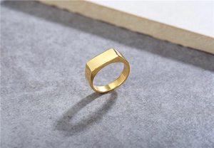 Macro detail of minimalist gold titanium steel ring featuring a smooth rectangular flat top