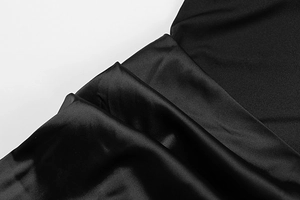 Gros plan sur un tissu en satin noir brillant avec une texture lisse et drapé élégant