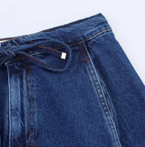 Dettaglio ravvicinato del tessuto denim blu scuro con cordoncino e cuciture di precisione