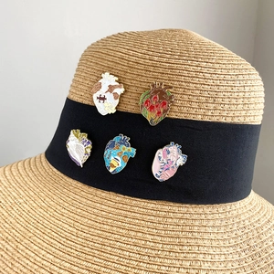 Artistic oil painting style heart enamel pins set displayed on a straw hat band