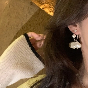 Eleganti orecchini a fiore con perle e petali bianchi indossati da una modella