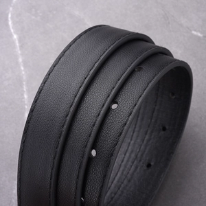 Close-up of black leather belt showing premium texture, stitching and buckle holes
