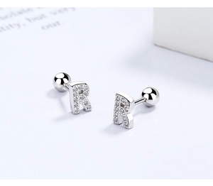 Macro shot of silver S925 letter R stud earrings with zircon stones and screw back