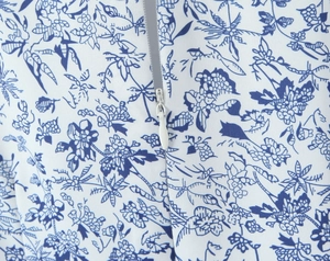 Close-up of invisible zipper closure on blue and white floral dress fabric detail
