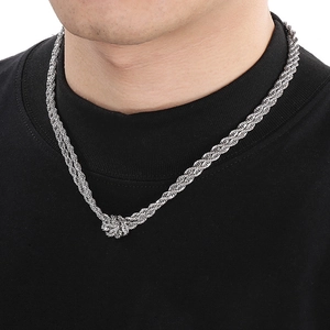 Close-up of a silver twist chain necklace with knot detail worn by a male model