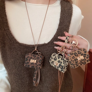 Detail of leopard print mini pouch pendant with metal clasp and chain on model