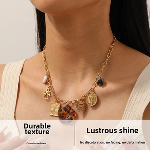 Close-up of vintage gold necklace featuring leopard print flower and embossed pendants
