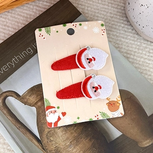Detailansicht von zwei roten bestickten Weihnachtsmann-Haarspangen für Weihnachten