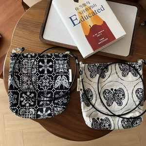 Sacs à bandoulière vintage en toile avec broderie florale sur table en bois