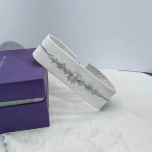 Detail of silver clover bracelet with white cat-eye stone and adjustable slider clasp