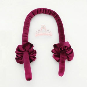 Platte lay van rode fluwelen hittevrije krulset met twee scrunchies en een roze haarklem