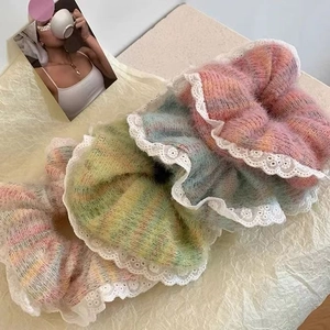 Detailed close-up of colorful knit scrunchies with elegant white lace trim detail