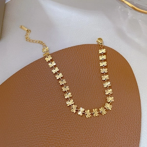 Detail of gold titanium steel clover chain bracelet with lobster clasp and extender