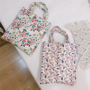Gros plan sur des mini sacs en toile à motifs floraux et fruités avec boutons pression