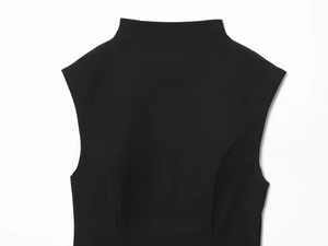 Detail of high neck and shoulder cut on a black slim fit dress with tight fabric texture
