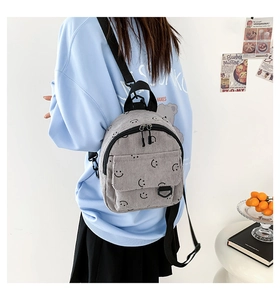 Rückansicht eines Models mit grauem Cord-Minirucksack mit schwarzen Smiley-Mustern