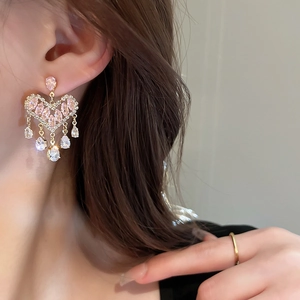 Detail of long tassel earrings with pink heart crystals and sparkling cubic zirconia drops