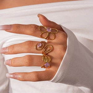 Detailed view of three gold-plated rings set with purple zircons on a model's hand