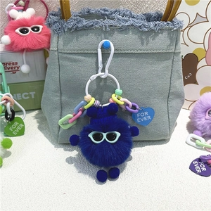 Porte-clés monstre en peluche bleu avec lunettes de soleil sur sac en jean