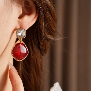 Gros plan de boucles d'oreilles vintage avec pierres rouges en losange et bords dorés