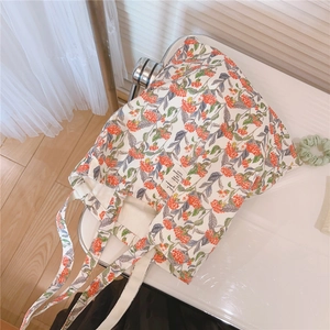Detailaufnahme einer Canvas-Einkaufstasche mit Blumenmuster auf einem weißen Tisch