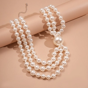 Detailed view of the triple-layer pearl necklace featuring a large round pearl pendant
