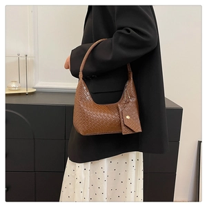 Detail of a brown woven texture shoulder bag with small coin purse accessory