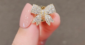 Vue macro d'une broche nœud dorée sertie de zircons cubiques pour chemises et vêtements
