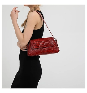 Professional model showing the red crocodile pattern leather shoulder bag on a grey background