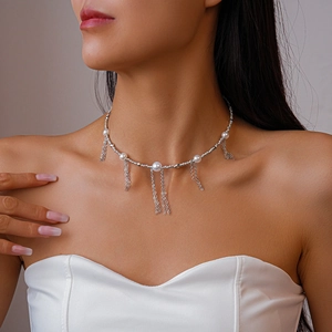 Detail of silver tassel necklace with imitation pearls on a model's neck