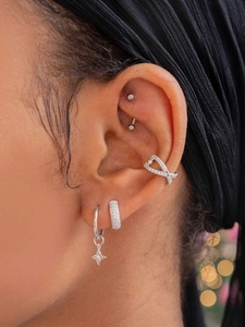 Detailed view of layered silver ear cuffs and studs with sparkling zircon stones
