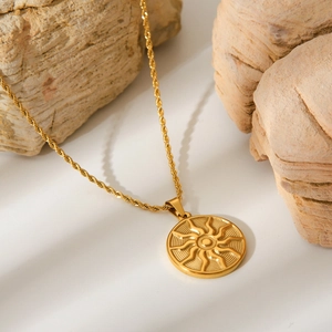 Golden stainless steel sun totem pendant necklace with twisted rope chain on stone
