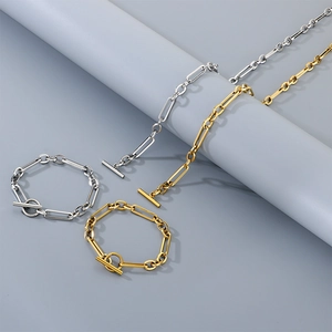 Vue détaillée de colliers et bracelets à fermoir OT dorés et argentés sur papier gris
