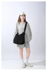 Vista completa di modella con borsa a tracolla in tela nera capiente per donna