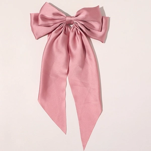 Elegant pink satin bow hair clip for women with a glossy finish on a clean background