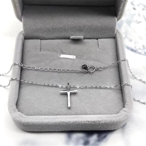 Close-up of S925 sterling silver cross necklace inside a premium gray velvet jewelry box