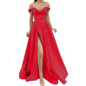 Detail view of the high slit and silky red fabric on the strapless V-neck evening gown
