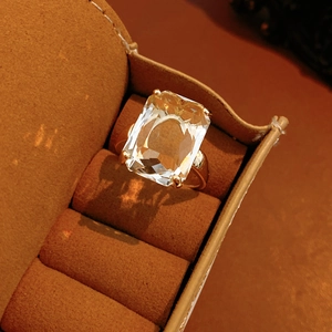 Macro detail of rectangle-cut zircon ring with 14k gold plating in a brown velvet box