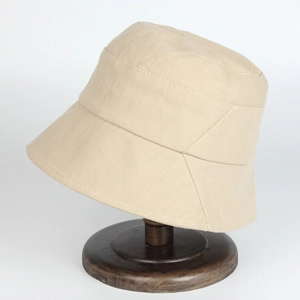 Minimalist beige cotton canvas sun hat for women on a dark wooden display stand