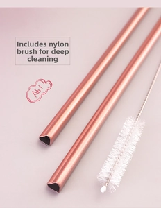 Detail of two rose gold heart-shaped stainless steel straws with a white cleaning brush